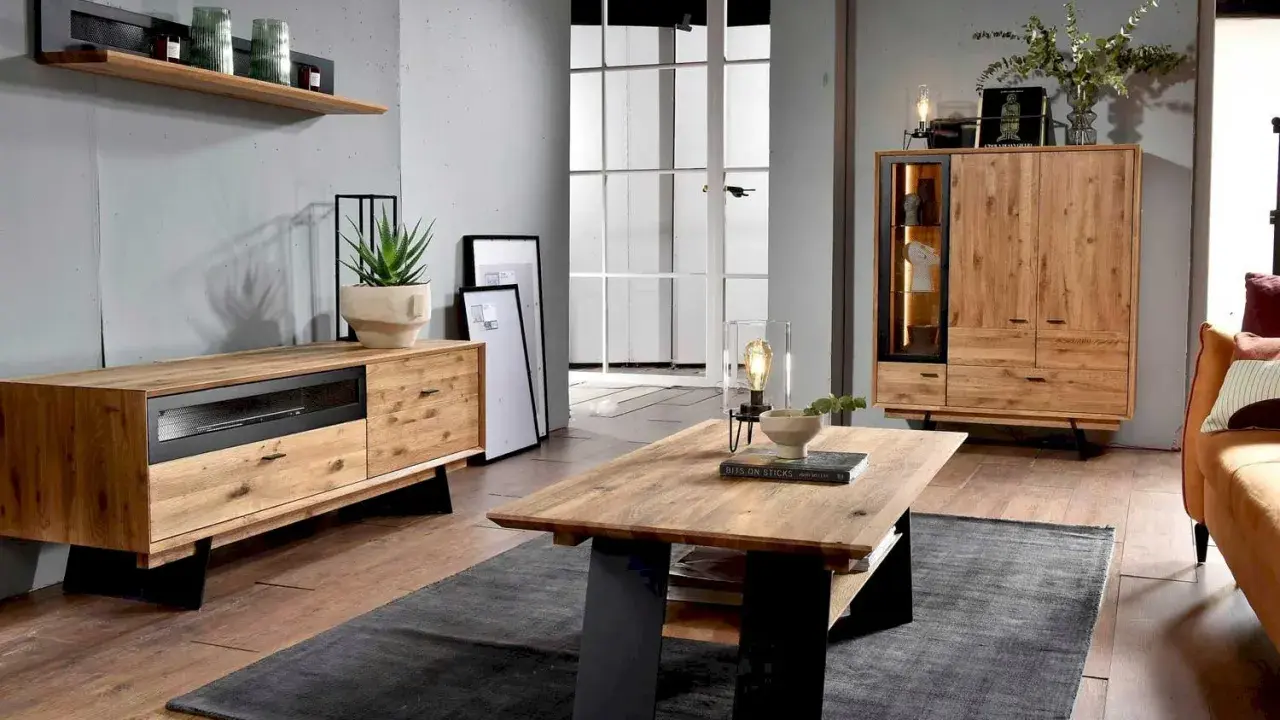 Przytulny salon boho loft z drewnianymi meblami, szarym dywanem i roślinami.