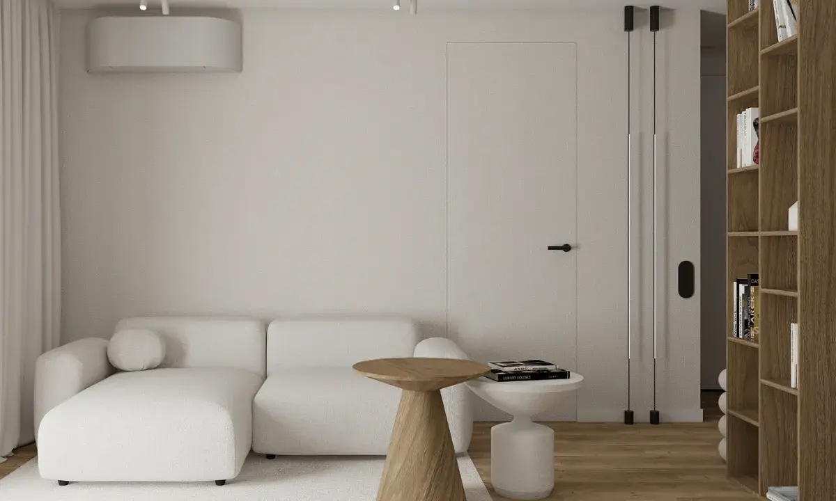 Przytulny salon w stylu wabi sabi. Jasna kanapa, drewniane stoliki i regał tworzą harmonię.