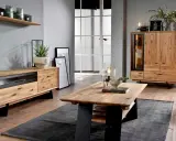 Przytulny salon boho loft z drewnianymi meblami, szarym dywanem i roślinami.