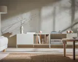Jasnoszare ściany idealnie komponują się z kaszmirowymi meblami, tworząc przytulną atmosferę. Wnętrze zdobią subtelne dekoracje i sprzęt audio.