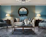 Elegancki salon w stylu włoskim: błękitne ściany, wygodna sofa, fotele, stolik kawowy i dywan z geometrycznym wzorem.