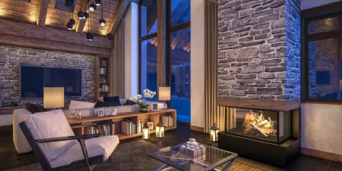 Przytulny salon w stylu chalet z kamiennym kominkiem, drewnianymi belkami i dużymi oknami.