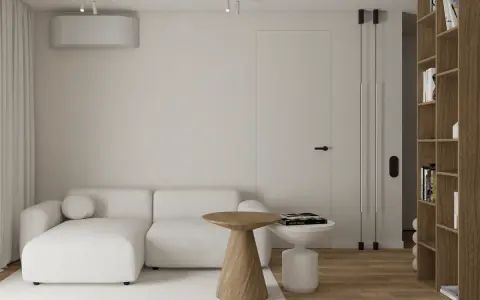 Przytulny salon w stylu wabi sabi. Jasna kanapa, drewniane stoliki i regał tworzą harmonię.