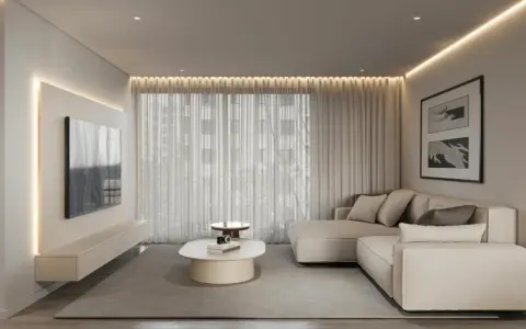 Nowoczesny salon w stylu minimalizm we wnętrzach. Jasna kanapa, telewizor na ścianie, owalny stolik kawowy i subtelne oświetlenie tworzą spokojną atmosferę.