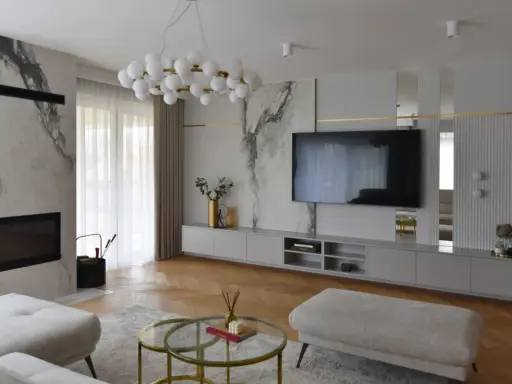 Elegancka ściana z TV glamour, z marmurowymi akcentami i złotymi detalami.