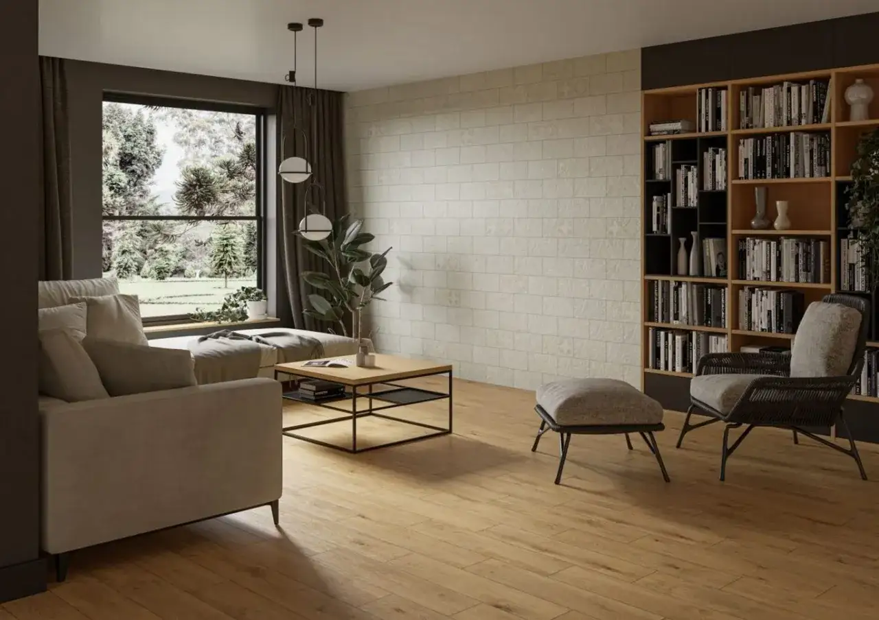 Przytulny salon inspiracje: jasna sofa, stolik kawowy, regał z książkami i wygodny fotel. Duże okno z widokiem na zieleń.